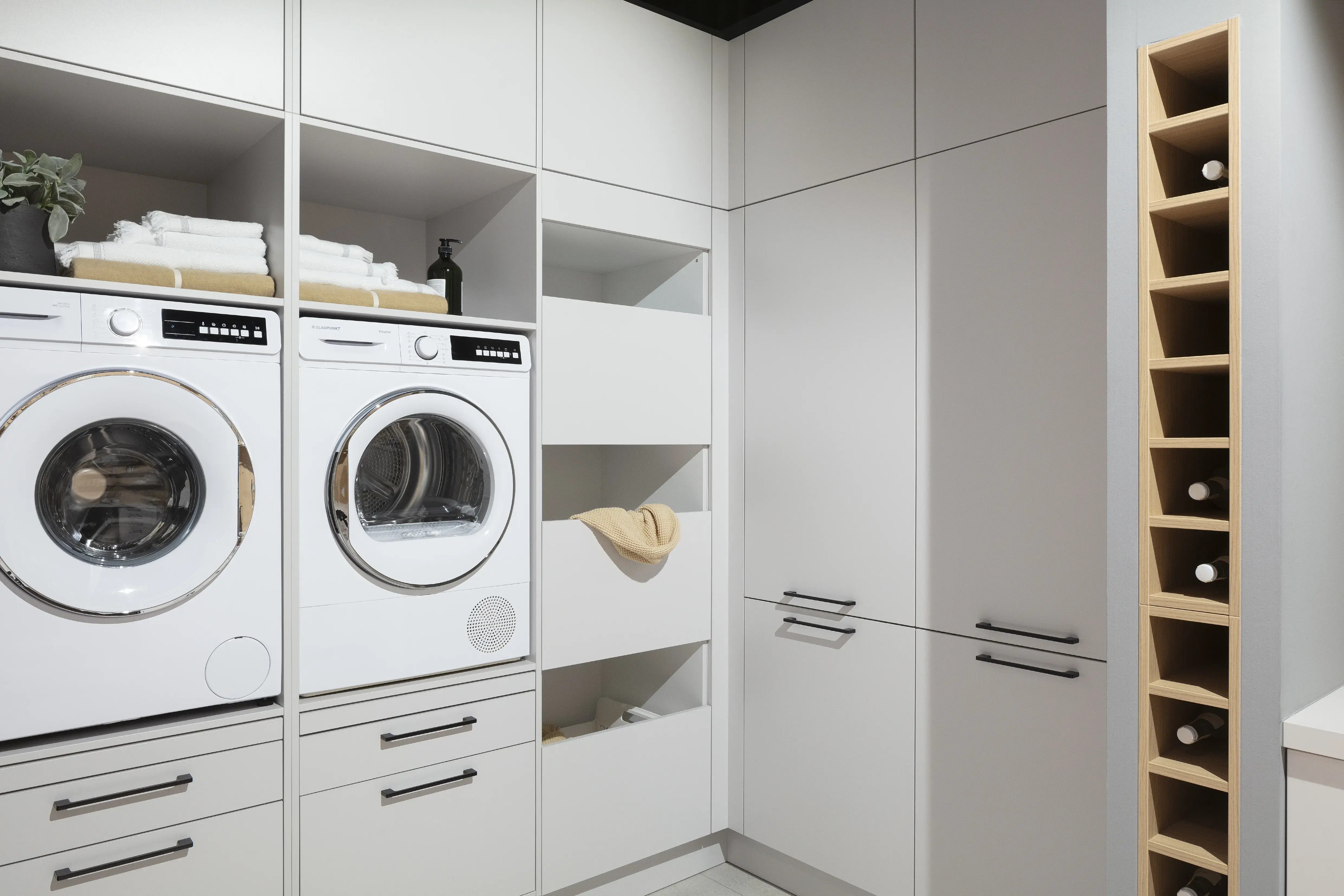 Häcker Hauswirtschaftsraum mit Waschmaschine und Trockner von Blaupunkt. 