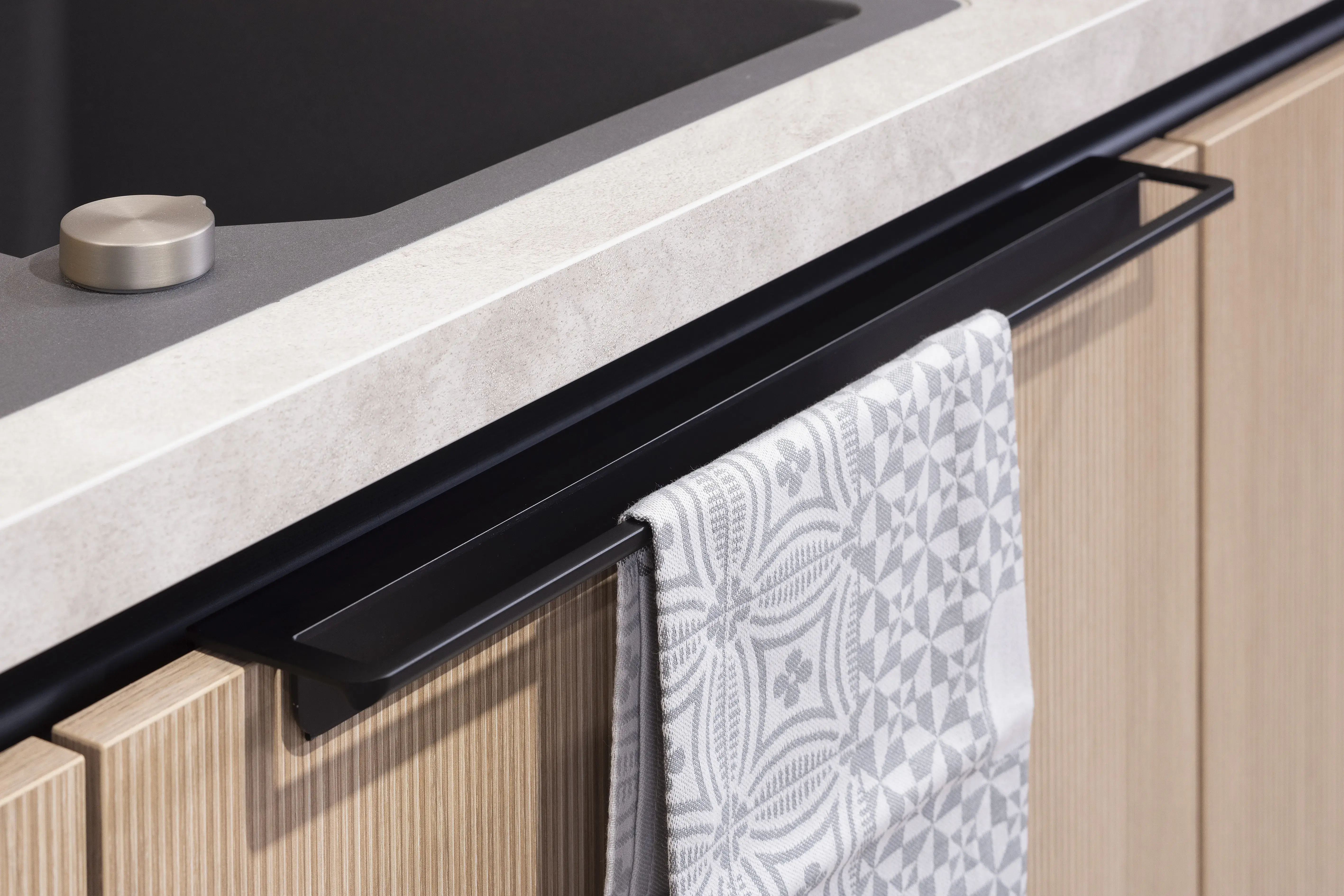 APL: Sandstein beige NB Front: Rillenoptik Eiche natur NB Front: MAC Tiefblau matt Korpus: Lavaschwarz Griff: Metallgriff Schwarz Geräte: Juno, Muldenlüfter BORA Armatur: Franke Spüle: Franke   Features: Kücheninsel mit Theke, Fliesen in Nischenrückwand, eingekoffertes Sideboard, Lichtstimmungen, offene Regale, Handtuchhalter Clip für Unterschranktüren, Kompaktbackofen, Planung ohne Sockel bodentief. 